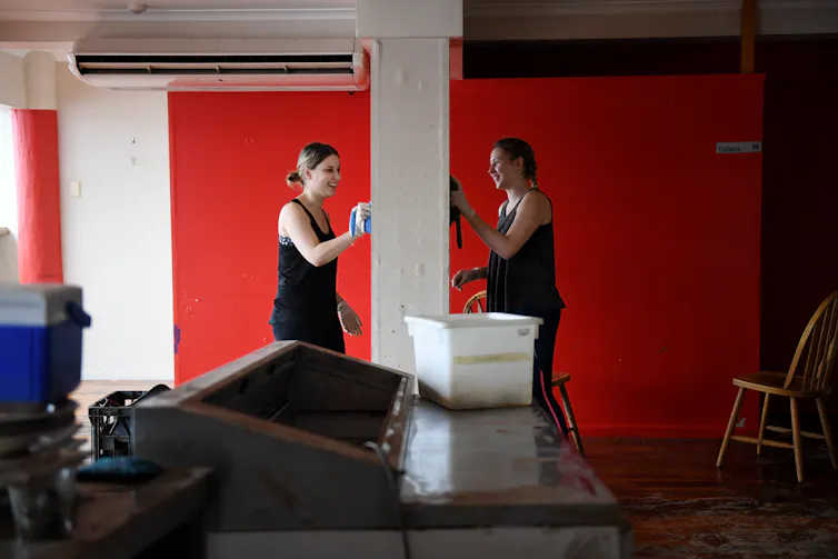 Two women wipe walls