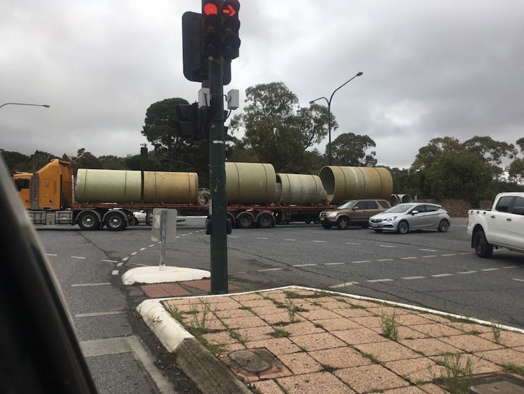 b-double truck and cars travel through an intersection