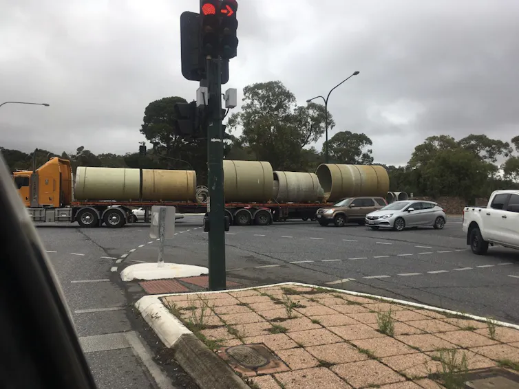 b-double truck and cars travel through an intersection