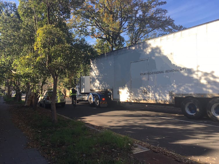 heavy truck passes a cyclist on residential road