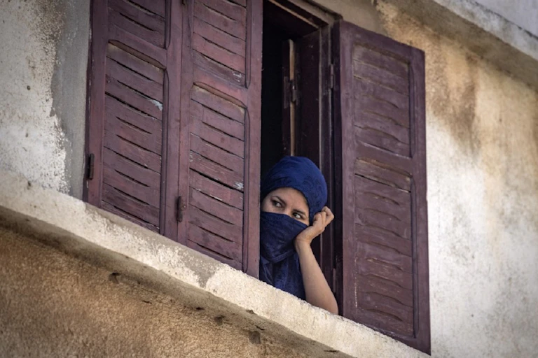 Une femme de la ville de Safi jette un œil dans la rue, pendant le confinement total de juin 2020.