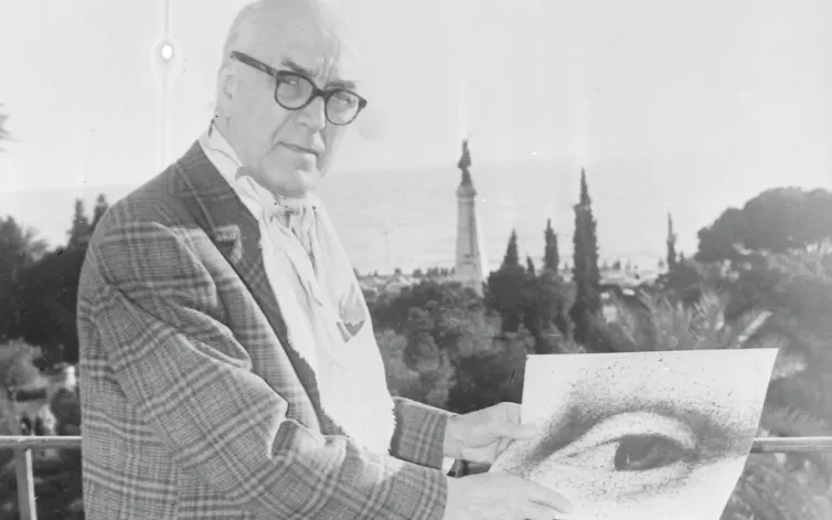Man in glasses stands with a close up image of Mona Lisa's eye.