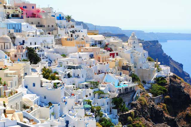 White-walled buildings cover a sunny hillside