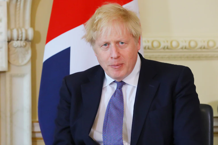 Boris Johnson sitting in front of a union flag.