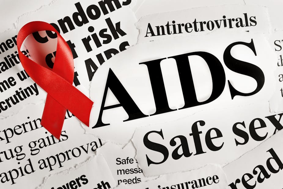 Red AIDS ribbon on headlines concerning the disease