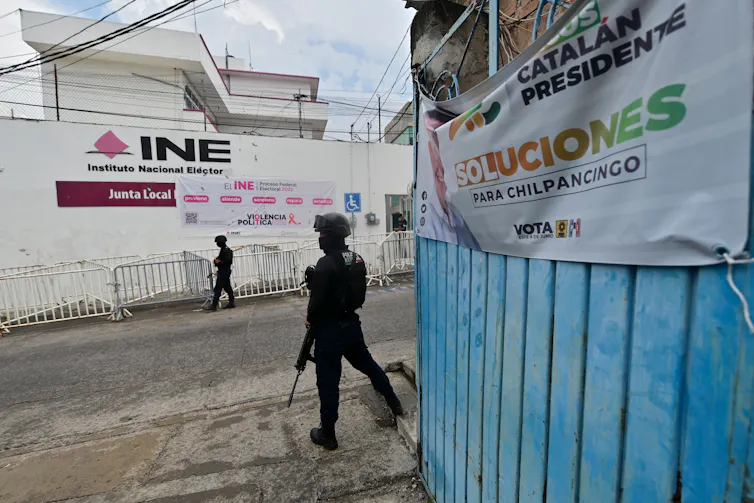 Armed policemen stand outside a building