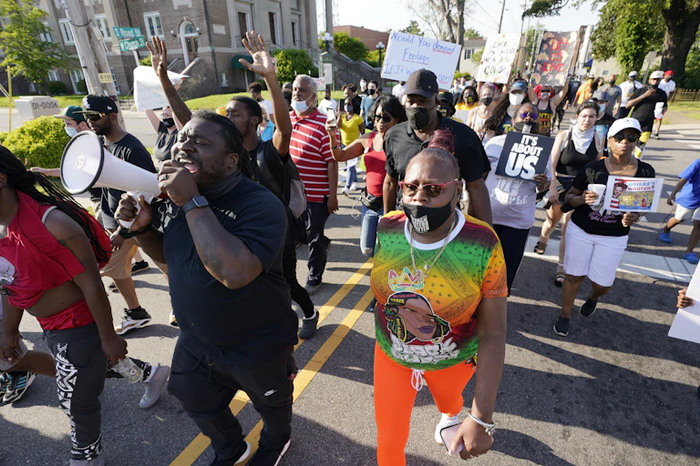 A group of people protesting the police shooting of Andrew Brown Jr., marching along South Road in Elizabeth City, North Carolina.