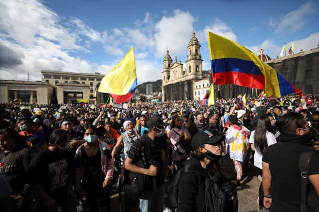 Protesters waving the Colombian flag gather in a protest.