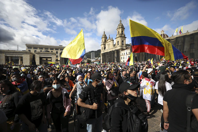 Protesters waving the Colombian flag gather in a protest.