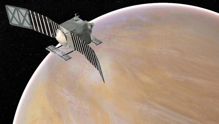 A square satellite with two long solar panels above a tanâ&#128;&#147;colored Venus.