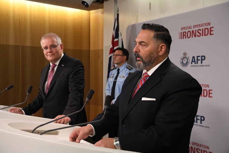 Scott Morrison and police official stand at lecterns