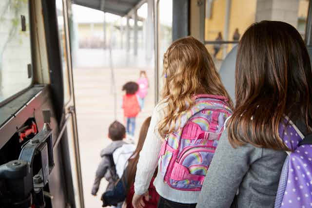 Girls getting off school bus