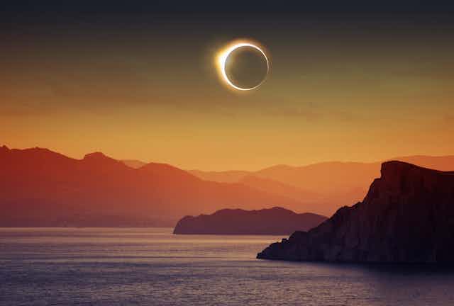 A solar eclipse above an ocean.