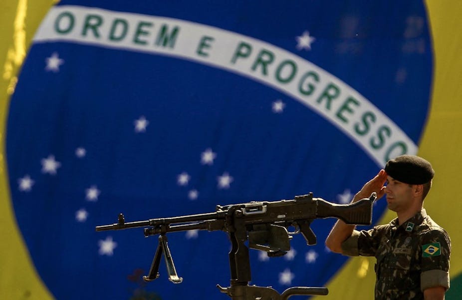 A soldier stands guard in front of the Brazilian national flag on Army Day in Sao Paulo, 18 April 2019.