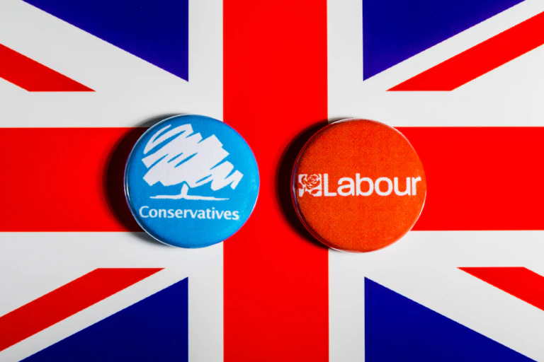 Union Jack flag with Conservatiive and Labour badges on it