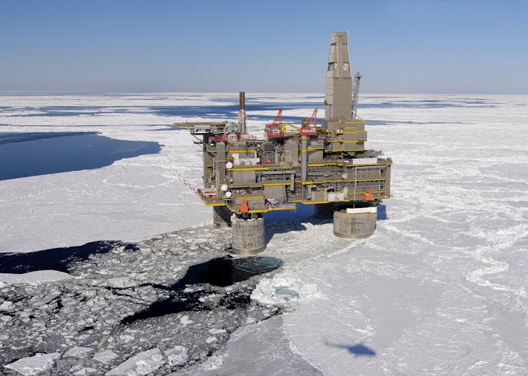 An oil and gas platform stands in icy waters