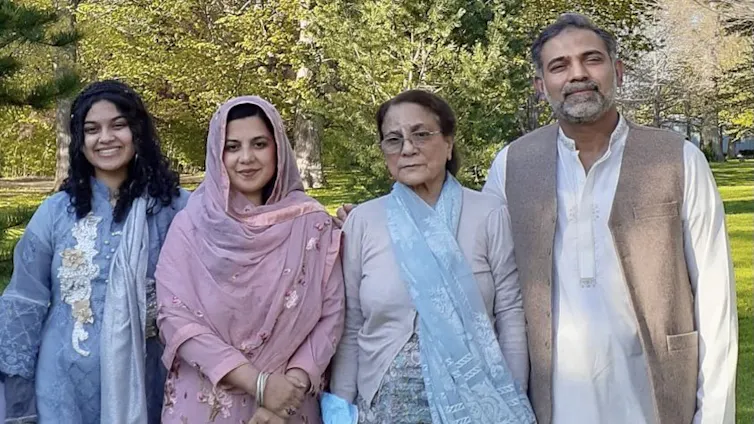 Four members of a family line up for a family photo