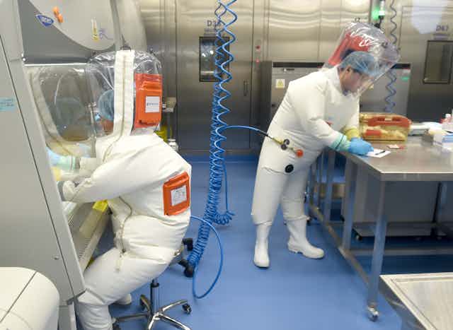 lab workers in biosafety suits