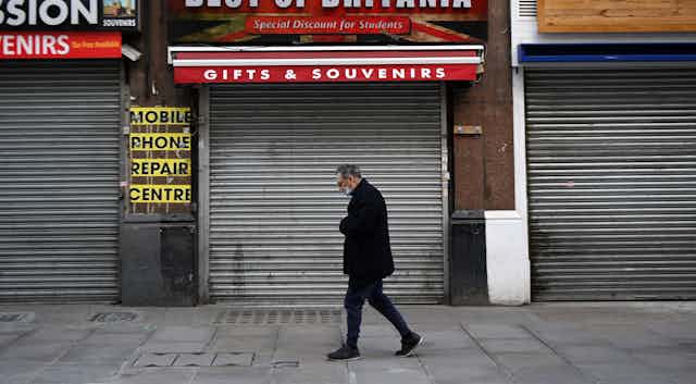 A man walking past closed shops