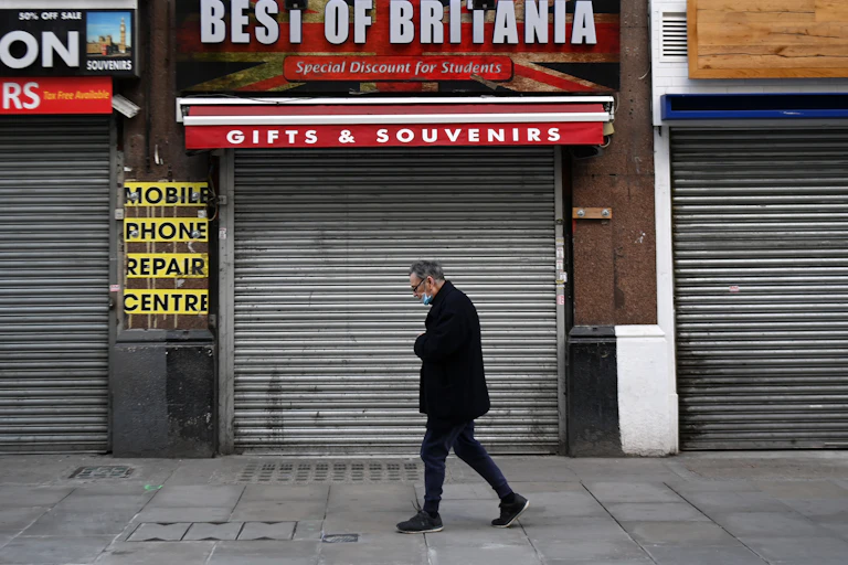 A man walking past closed shops