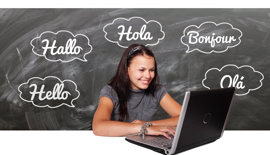 A girl at a computer surrounded by speech bubbles saying 'hello', 'hallo', 'hola', 'bonjour' and 'ola'