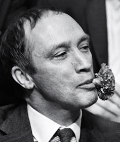 Pierre Trudeau with a carnation in his mouth.
