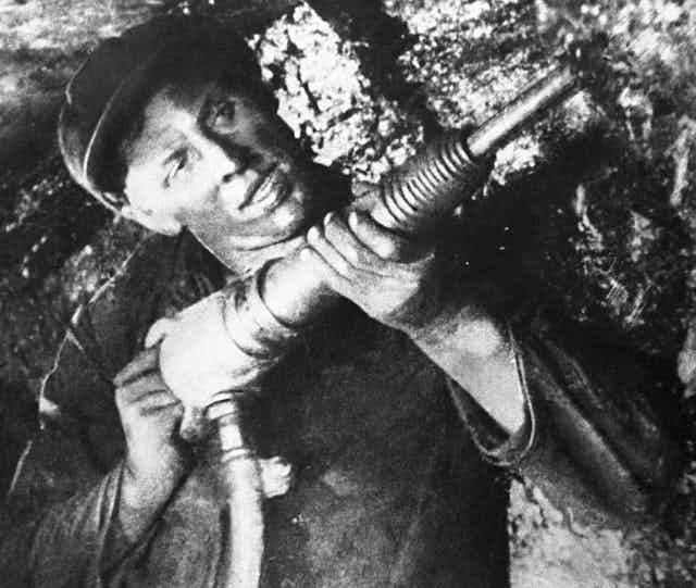 Man drilling in coal mine.