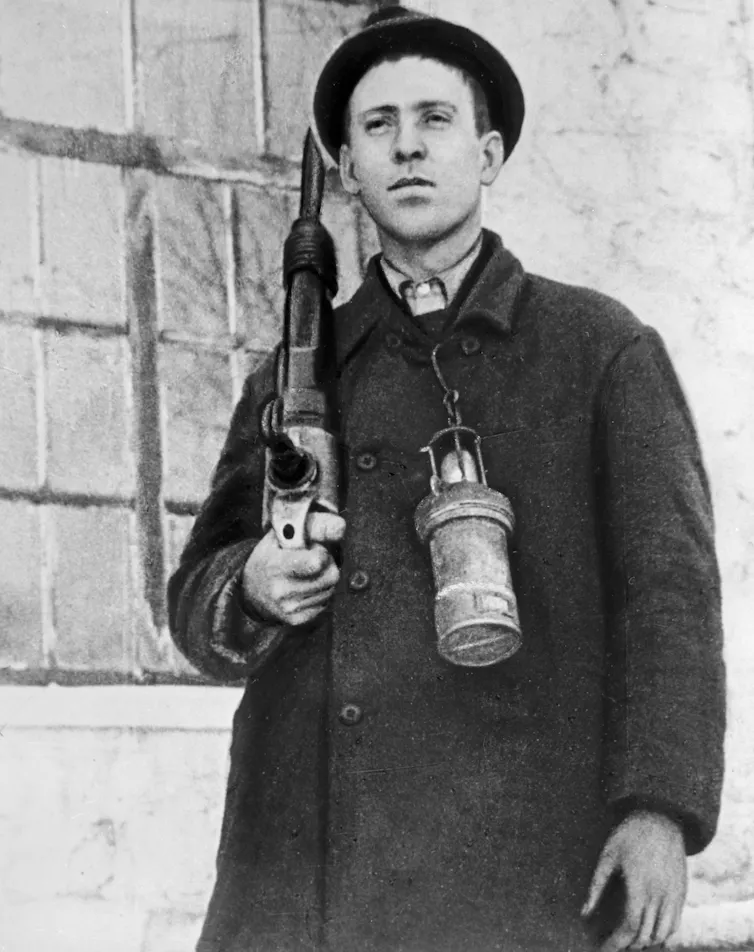 Miner holding a drill.