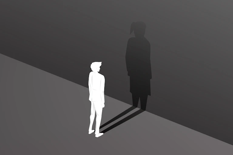 Silhouette of male and his bigger shadow as a female against a wall.
