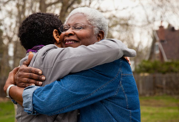 A older women hugs her daughter.