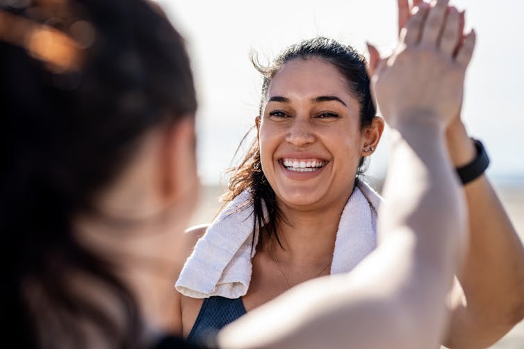 Person smiling and high-fiving friend while exercising