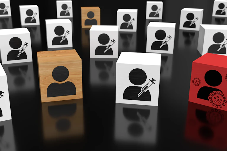 Blocks representing vaccinated people, unvaccinated people and an infected person