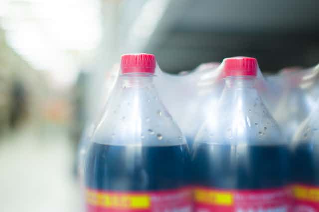 Cola bottles appear in plastic wrap.