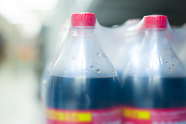 Cola bottles appear in plastic wrap.