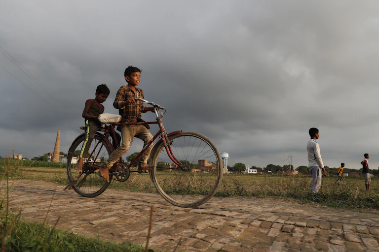 Indian children riding on a bike.