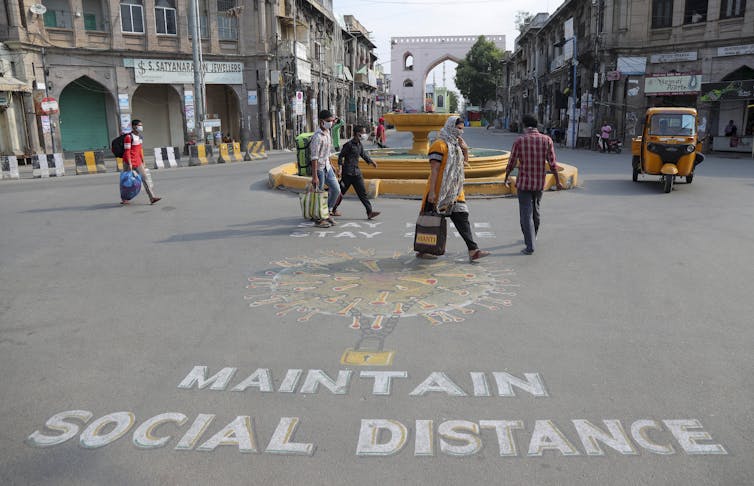 A sign advises locals to 'maintain social distance' in a Hyderabad street.