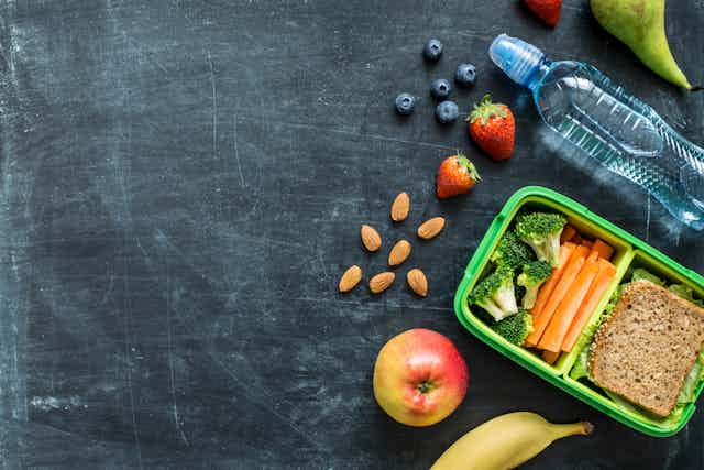 A healthy lunch is unpacked on a blackboard.