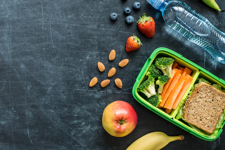 A healthy lunch is unpacked on a blackboard.