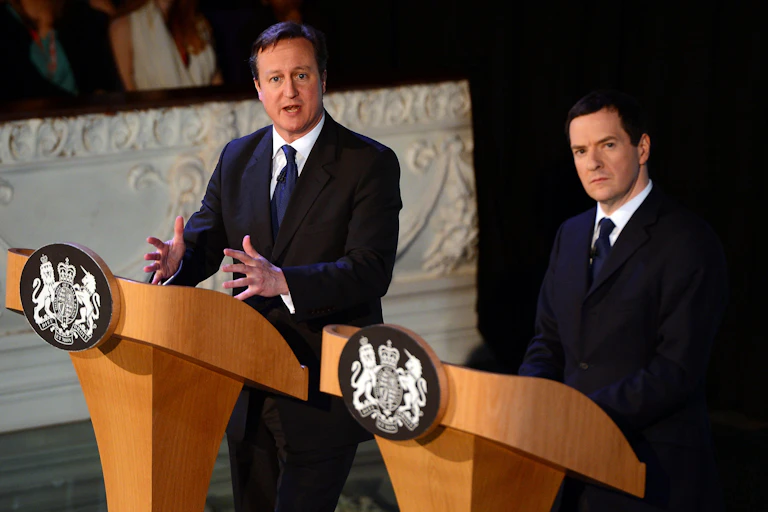David Cameron and George Osborne giving a speech.