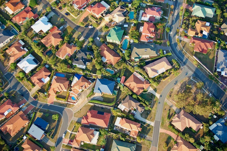 Aerial view of detached houses and gardens.