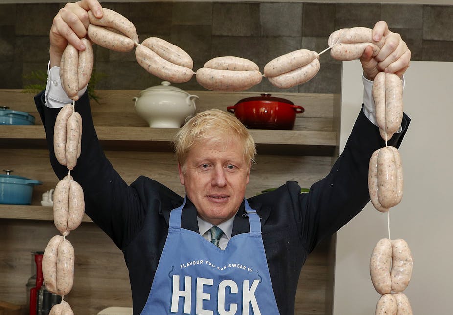 UK Prime minister Boris Johnson holds up a string of sausages