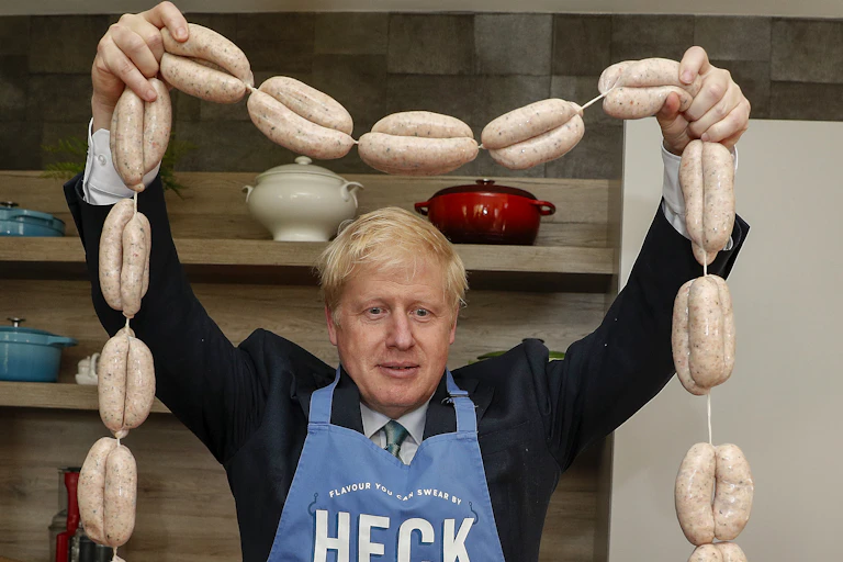 UK Prime minister Boris Johnson holds up a string of sausages