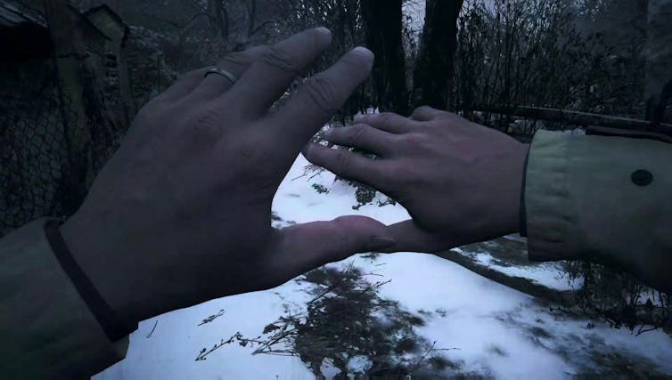 Screen view of two hands stretched out over a snowy landscape.