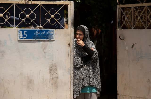A Palestinian woman looks around a gate in the Sheikh Jarrah neighborhood of east Jurusalem.
