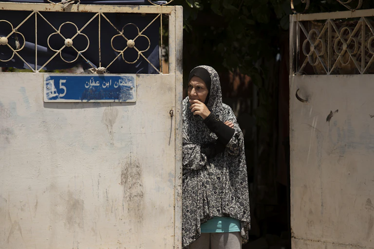 A Palestinian woman looks around a gate in the Sheikh Jarrah neighborhood of east Jurusalem.