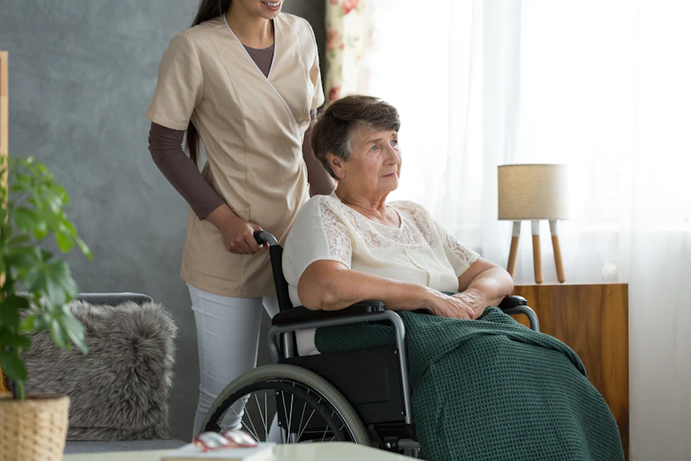 A woman in a wheelchair pushed by an attendant.