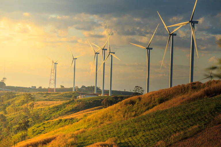 Wind turbines on a hill at sunset