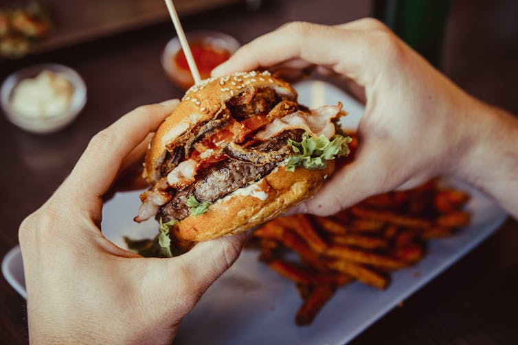 A man eating a burger and chips