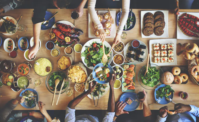 A table of friends eating a variety of food dishes