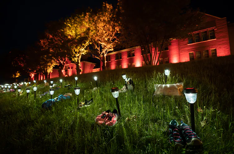 Shoes are placed on the lawn outside the former Kamloops Indian Residential School.